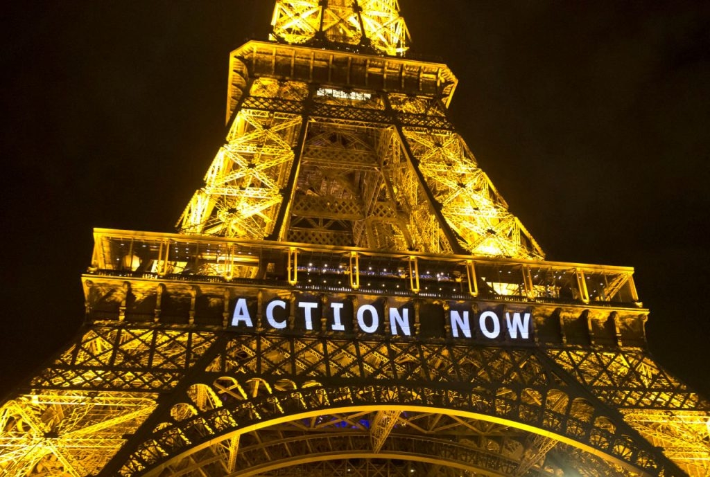 The Eiffel Tower lights up with the slogan"Action Now"referring to the COP21, United Nations Climate Change Conference in Paris, Sunday, Dec. 6, 2015. Negotiators adopted a draft climate agreement Saturday that was cluttered with brackets and competing options, leaving ministers with the job of untangling key sticking points in what is envisioned to become a lasting, universal pact to fight global warming. (AP Photo/Michel Euler)